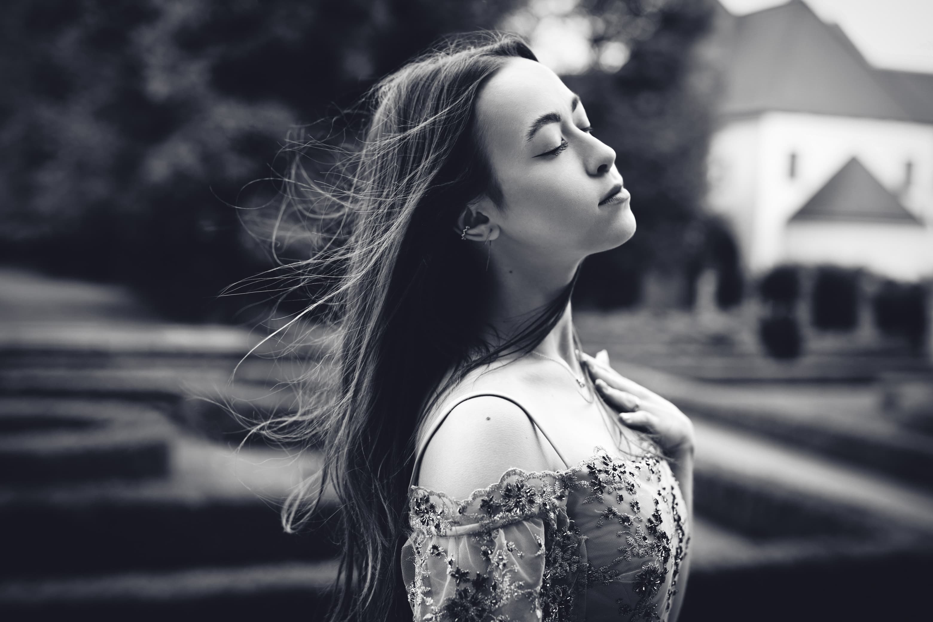 Portret kobiety z zamkniętymi oczami i rozwianymi włosami — naturalny, spokojny